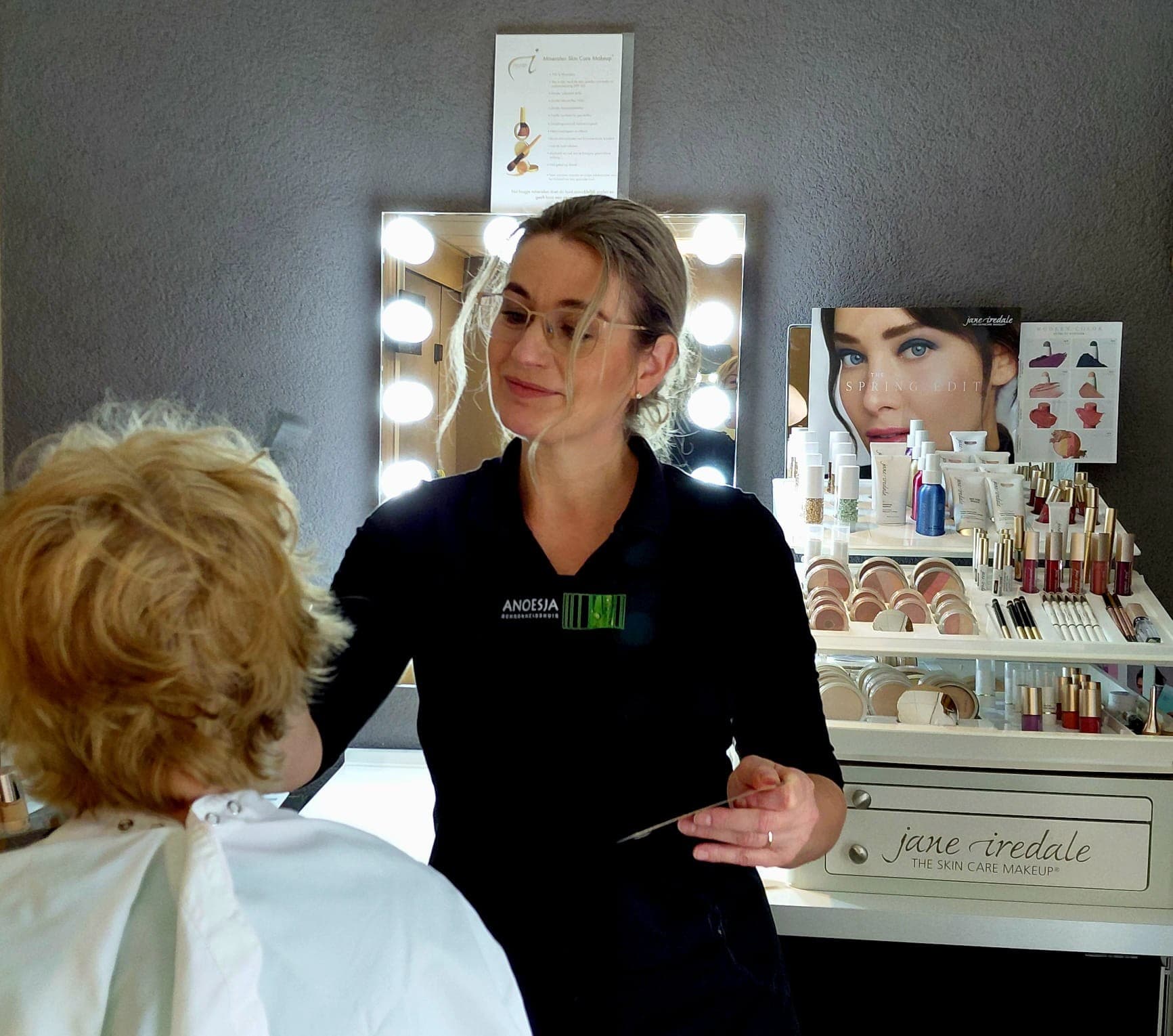 Anoesja geeft een make-upbehandeling aan de visagietafel